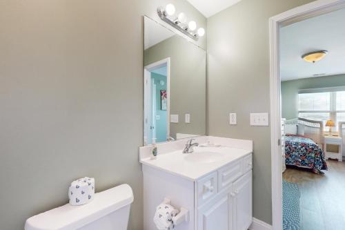 a bathroom with a sink and a toilet and a mirror at Escape to Ocean Isle in Ocean Isle Beach