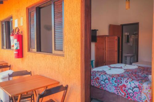 a bedroom with a table and a bed and a window at Pousada Acqua Infinity PISCINA CLIMATIZADA PÉ NA AREIA in Bertioga