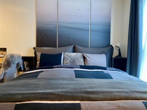 een slaapkamer met een groot bed en een schilderij aan de muur bij Experience a Cozy Getaway Near Pulpit Rock in Strand