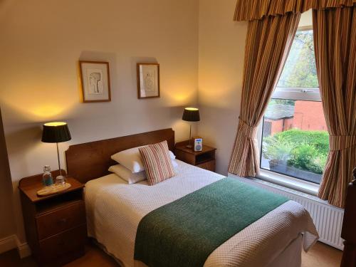 a bedroom with a bed and a large window at Roseleigh House in Belfast