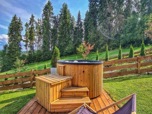 ワプシェ・ニジネにあるLK Resort Łapsze domy z prywatną balią i saunąの木製デッキに座った木製ホットタブ