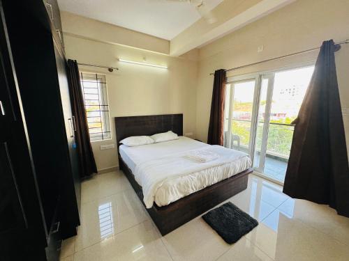 a bedroom with a bed and a large window at Oryx Residences - Luxury Serviced Apartments in Mysore