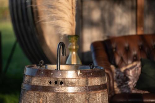 a faucet in a barrel with a cat in a vase at Tiny Wineyhouse 3 in Zennewijnen