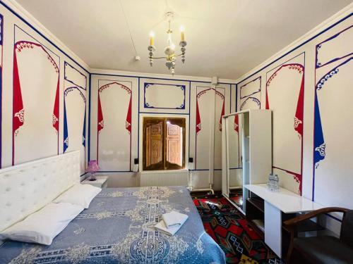um quarto com uma cama, uma mesa e uma janela em Hotel Chorminor Old Premium Est-Since 2003 Mekhtar anbar str131 em Bukhara