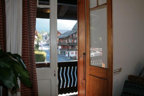 a door to a balcony with a view of a city at Chalet la Griotte in Villars-sur-Ollon