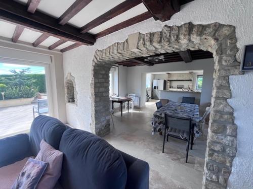 - un salon avec un canapé bleu et une cheminée en pierre dans l'établissement Villa CHESTER 9 km d'Omaha Beach, à Trévières