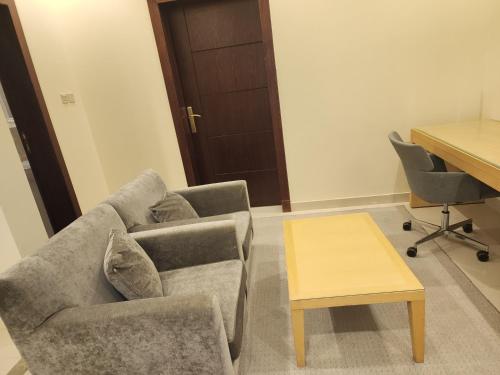 - un salon avec un canapé et une table dans l'établissement شقق سكاي الفندقية, à Arar