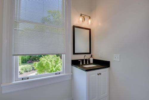a bathroom with a sink and a window with a mirror at Matchpoint House Aiken in Aiken