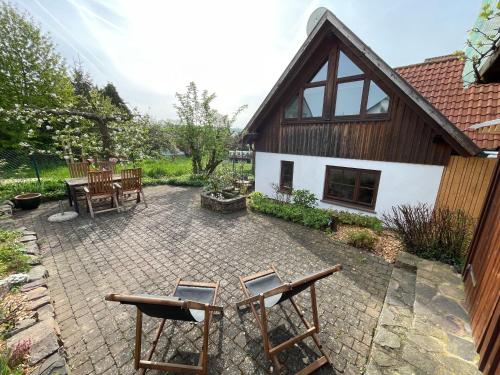 a patio with chairs and tables in front of a house at Ferienhaus Casa Maja in Bad Camberg