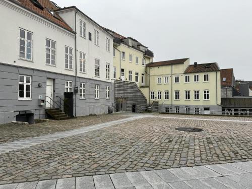 a group of buildings sitting next to a street at aday - Randers Beautiful Central 2 bedrooms Apartment in Randers