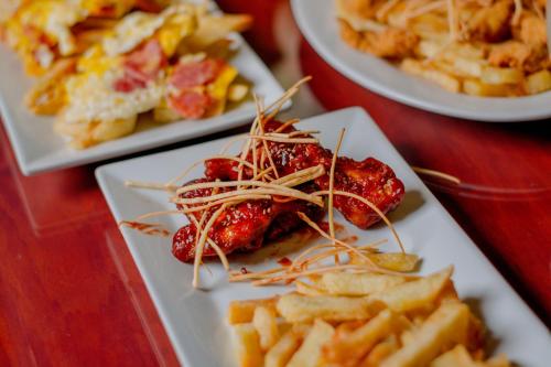drie borden met eten op een tafel met frietjes bij Real Hotel in Huánuco