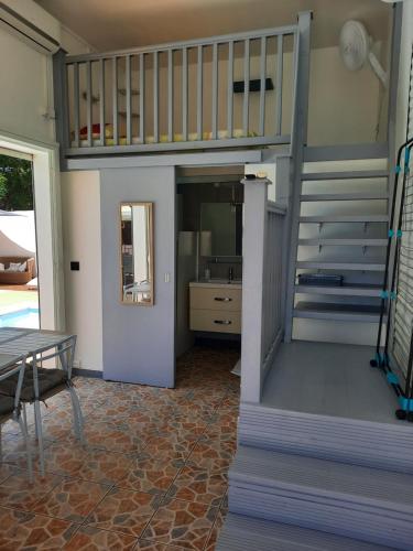 een woonkamer met een trap en een tafel en een tafel bij Studio avec piscine, idéalement situé in Saint-Claude