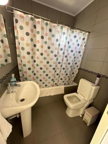 a bathroom with a sink and a toilet and a shower curtain at Serenity Corner in Paphos