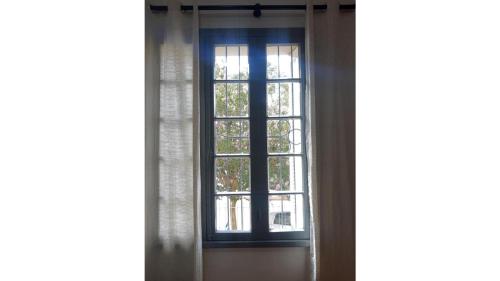 a window in a room with a curtain at Hospedagem 154 Colonial in Gramado