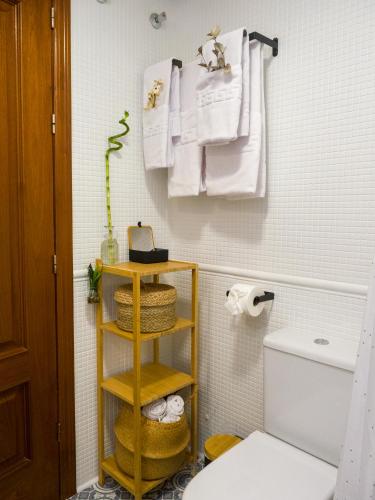 a bathroom with a towel rack and a toilet at El descanso de Wallada, Junto al Puente Romano, fácil aparcamiento y tranquilidad in Córdoba