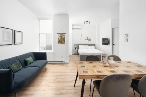 een woonkamer met een bank, een tafel en een bed bij Boutique Lofts Notre Dame - Vieux Montréal in Montreal