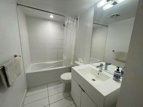 a bathroom with a sink and a toilet and a tub at Toronto Downtown suite in Toronto