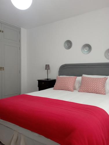 ein Schlafzimmer mit einem großen Bett mit einer roten Decke in der Unterkunft Pisovistalegre in Vilagarcia de Arousa