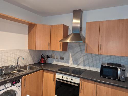 uma cozinha com um lavatório e um micro-ondas em The Pinnacle 4/5 em Glasgow