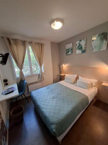 une chambre avec un grand lit, un bureau et une fenêtre dans l'établissement Hotel Au Bon Sejour, à Vitry-le-François