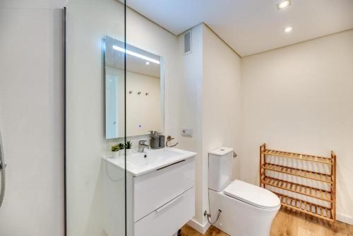 a white bathroom with a toilet and a sink at golf y playa in Benalmádena