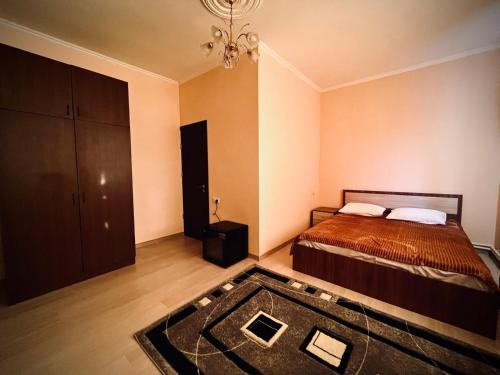 ein Schlafzimmer mit einem Bett, einem Teppich und einem Kronleuchter in der Unterkunft Red house in Kʼasakh