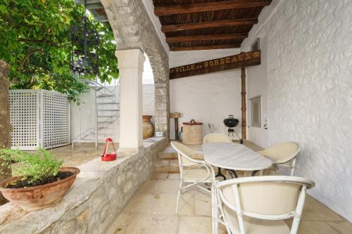 a patio with a table and chairs on a wall at Livin Hydra Private Collection Suite 1 in Hydra