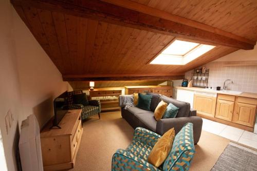 Il comprend un grand salon avec des canapés et une cuisine. dans l'établissement Gorgeous 1 bedroom apartment in Meribel main town, à Les Allues