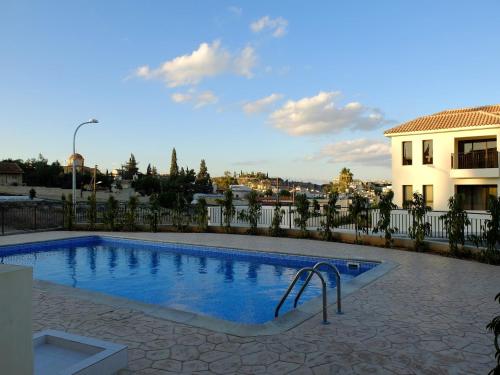 a swimming pool with a slide in front of a building at Kosher Tersefanou Larnaca in Larnaka