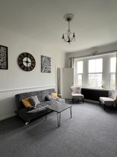 a living room with a couch and a table at Sea Spray Victorian Apartment in St. Leonards