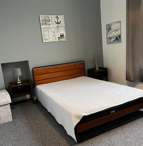 a bedroom with a bed and two nightstanduments sidx sidx sidx sidx at Sea Spray Victorian Apartment in St. Leonards