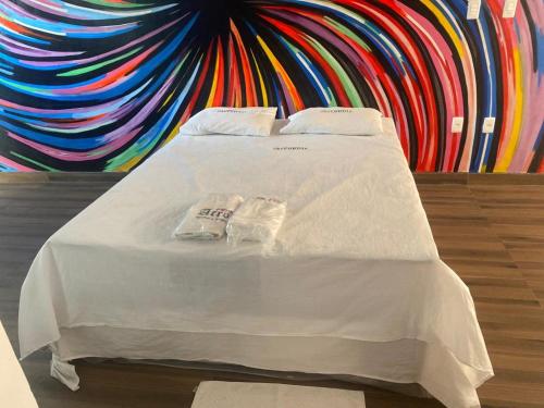 a bed in a room with a colorful wall at Pousada ACRÓPOLE in Belém