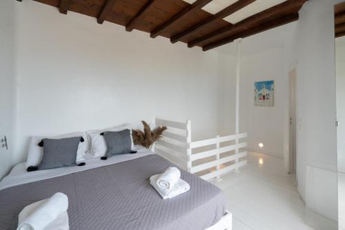 a white bedroom with a large bed with pillows at Villa Irilia, Private Pool with Unrestricted Sea View in Fanari