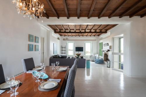 a dining room with a table and a living room at Villa Irilia, Private Pool with Unrestricted Sea View in Fanari