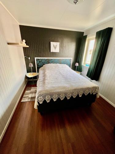 1 dormitorio con 1 cama y suelo de madera en Lofoten booking en Leknes