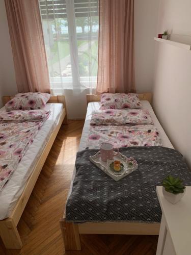 um quarto com duas camas com uma bandeja de comida em Füge Vendégház Csopak em Csopak