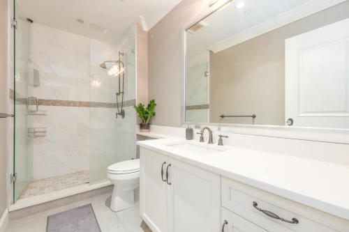 y baño con aseo, lavabo y ducha. en Luxurious 6-Bedroom Mansion Near UBC en Vancouver