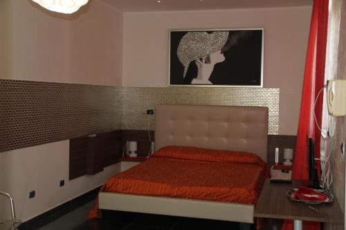 1 dormitorio con 1 cama con edredón rojo en B&B Valentino, en Bari