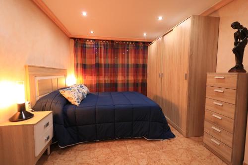 1 dormitorio con cama, tocador y espejo en Casa Juani, en Cehegín