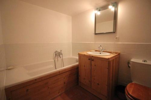 La salle de bains est pourvue d'une baignoire, d'un lavabo et de toilettes. dans l'établissement Atmospheric, original stone chalet in Meribel, à Les Allues