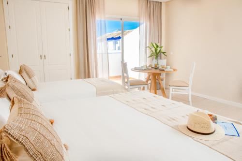 a hotel room with a bed and a table with chairs at Vive Costa Azul in Benalmádena