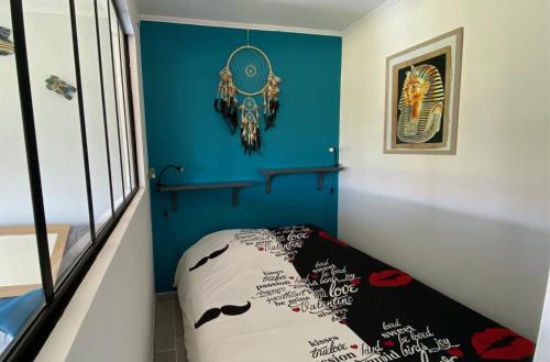 Cette chambre est dotée d'un mur bleu et d'un lit. dans l'établissement Carnon plage bord de mer et piscine, studio 1 chambre, à Mauguio