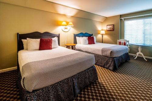 a hotel room with two beds and a window at Cambria Pines Lodge in Cambria