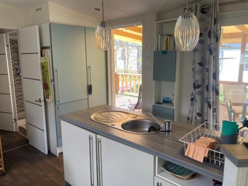 une cuisine avec un évier et un plan de travail dans l'établissement mobilhome entre montagne et lac près de Gap au calme, à Rochebrune