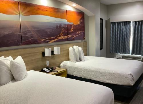 a hotel room with two beds and a painting on the wall at Days Inn by Wyndham Humble/Houston Intercontinental Airport in Humble