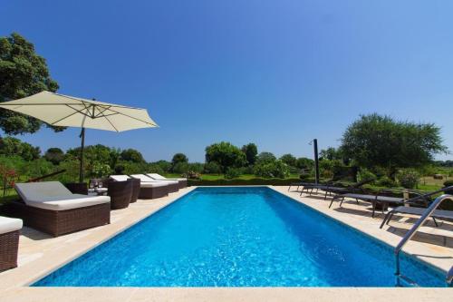 uma piscina com cadeiras e um guarda-sol em Ferienhaus mit Privatpool für 10 Personen ca 300 qm in Šišan, Istrien Südküste von Istrien em Sisan