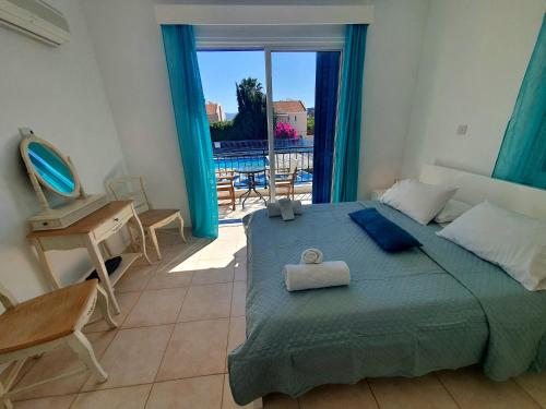 ein Schlafzimmer mit Bett, Schreibtisch und Fenster in der Unterkunft G&E HARBOUR MAISONETTE NUMBER 13 in Lachi