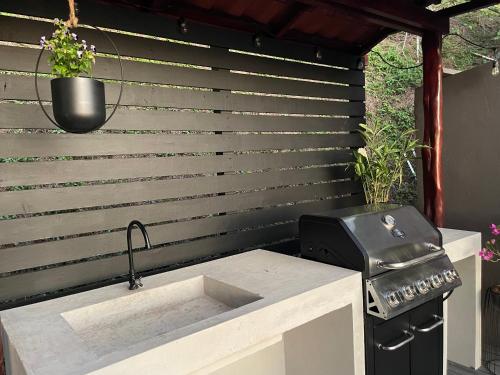 a outdoor kitchen with a sink and a grill at Villa Del Mar 2 Spectacular ocean view! in Dominical