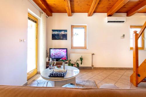 a living room with a table and a tv at Quiet family house Butterfly place in Dob