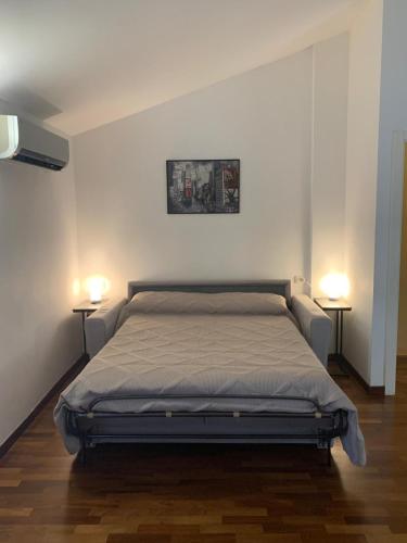 a bed in a room with two lights on two tables at Casa Giorgio in Fano